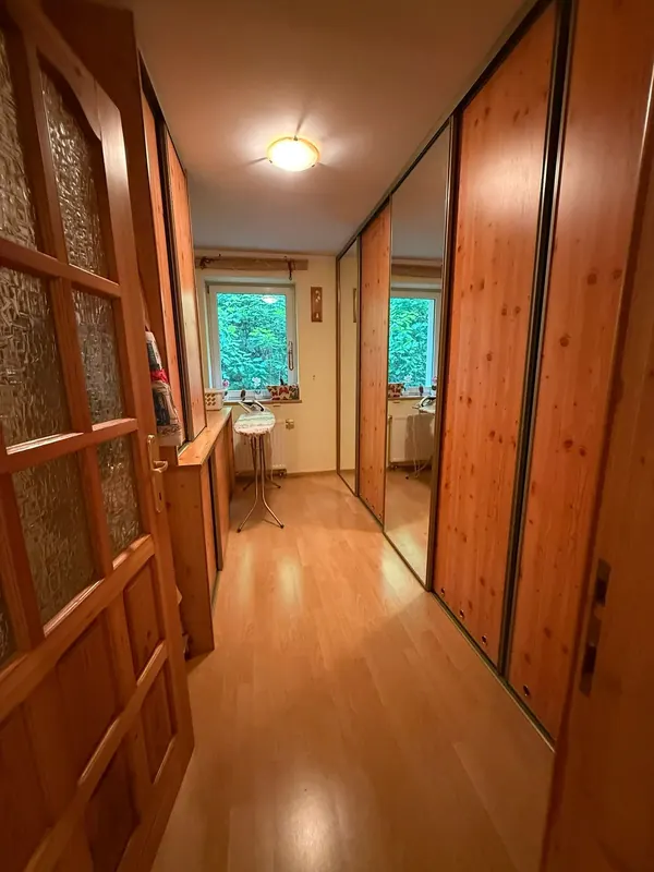 Garderoba z lustrzaną zabudową i oknem