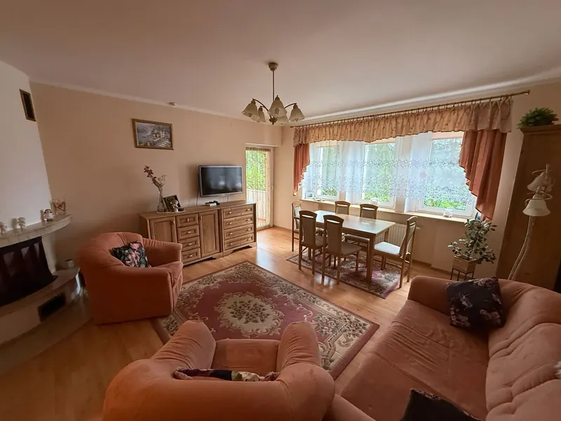 Jasny salon z marmurowym kominkiem i częścią jadalną, mieszkanie 111 m² w Jeleniej Górze